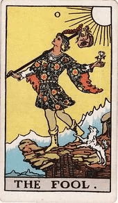 A young traveler steps toward a cliff's edge with a small white dog at his heels and a bindle over one shoulder.