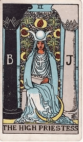The High Priestess sits between a black pillar and a white pillar, a crescent moon at her feet and a scroll marked TORA in her lap.