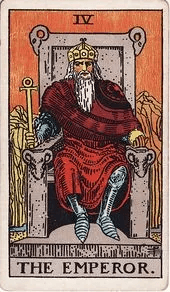 The Emperor sits on a stone throne carved with ram heads, holding an ankh and an orb, bare mountains behind him.
